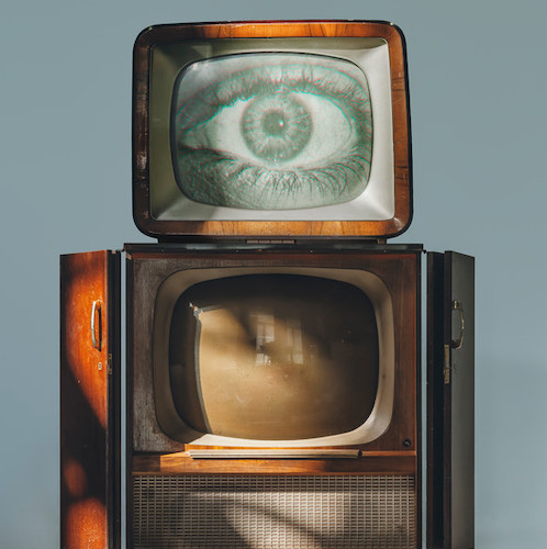 Futuristic image of an old television with an eye peering out of it - designed to convey a  relationship between sentient technology and humanity.